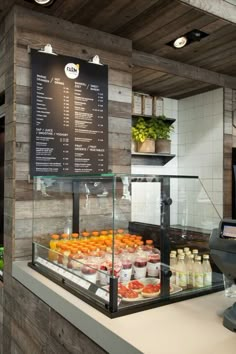 a display case filled with lots of food on top of a wooden wall next to a cash register