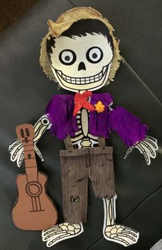 a paper doll with a guitar on the ground