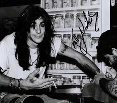 an autographed photo of two people in a store, one is pointing at the other's hand