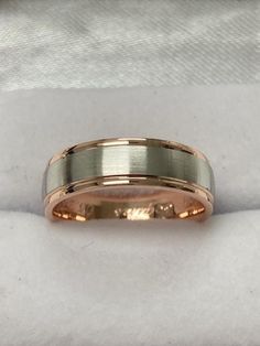 two tone gold wedding band on white cloth with the ring in it's center