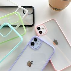 three iphone cases sitting next to each other on top of a white table with a cup of coffee