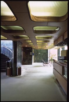 an empty lobby with lots of lights on the ceiling and stairs leading up to it