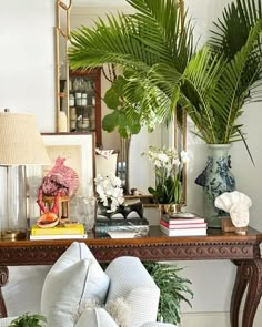 a living room filled with lots of furniture and plants on top of a wooden table