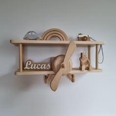 a wooden clock mounted to the side of a wall next to a shelf filled with toys