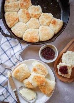 biscuits and jam in a cast iron skillet next to buttered biscuits