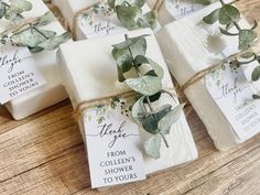 soaps wrapped in twine with greenery tied around them on a wooden table