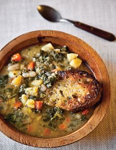 a wooden bowl filled with soup and meat