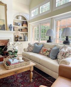 a living room filled with furniture and a fire place next to a window covered in lots of windows