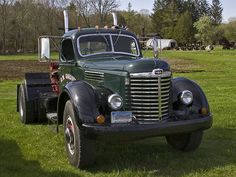 an old truck is parked in the grass