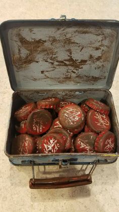 an old suitcase filled with red painted rocks