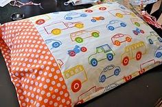 an orange and white pillow with cars on it