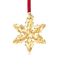 a gold snowflake ornament hanging from a red ribbon