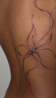 the back of a woman's stomach with a flower tattoo on it