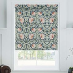 a window with a flowered roman blind in front of it