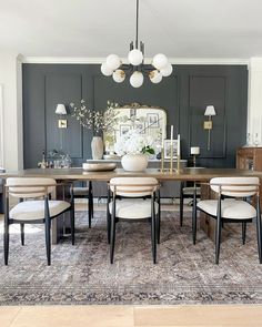 a dining room table with chairs and a rug on the floor in front of it