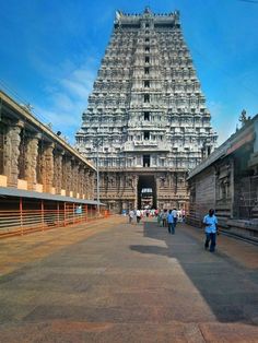 people walking in front of an ornate structure