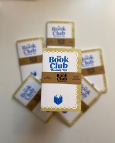 four books that are stacked on top of each other in front of a white table