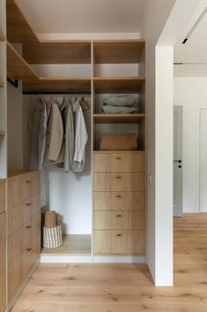 an open closet with wooden drawers and white walls