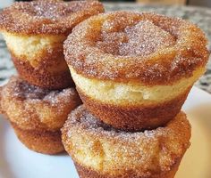 three sugared donuts stacked on top of each other in front of a plate