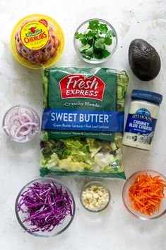 the ingredients to make this salad are laid out on a white surface, including carrots, celery, lettuce, and other vegetables