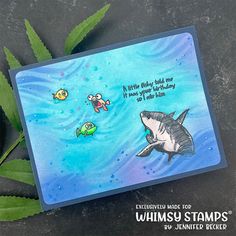 a card with an image of a shark and other marine creatures on it, next to some leaves