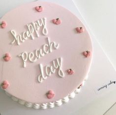 a pink cake with white frosting that says happy peach day