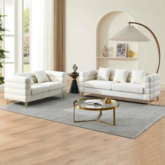 a living room with white couches and chairs in front of a large mirror on the wall