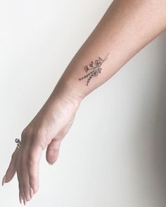 a woman's arm with a small tattoo on the left side of her hand