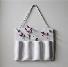 a white wall hanging with purple flowers on it