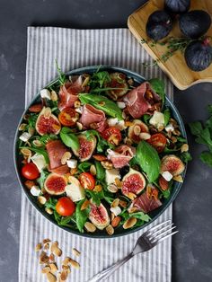 a salad with figs, tomatoes and nuts in a bowl