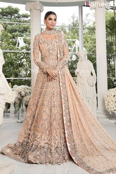 a woman standing in front of a window wearing a dress with an elaborate design on it