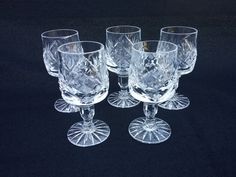 four clear glass goblets on a black background