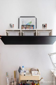 the shelf above the desk is filled with office supplies