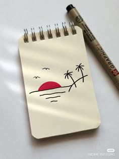 a notepad with a drawing of a sunset and palm trees