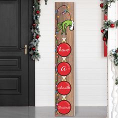 a wooden sign that says have a christmas ornament hanging from the side of a door