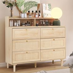 a dresser with lots of bottles on top of it next to a mirror and potted plant