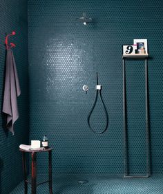 a bathroom with a shower head, towel rack and standup shower in the corner