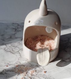 an animal shaped food dispenser sitting on top of a marble counter