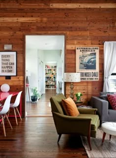 a living room filled with furniture and wooden walls