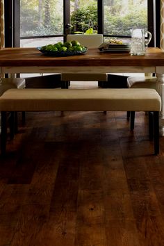 a dining room table with two benches in front of it and windows overlooking the trees