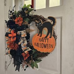 a halloween wreath with a black cat on it