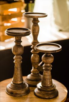 three wooden candlesticks sitting on top of a table