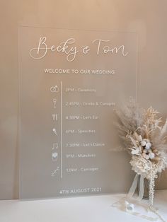 a wedding welcome sign with flowers in a vase