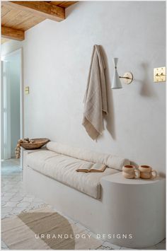 a white couch sitting next to a wall mounted coat rack