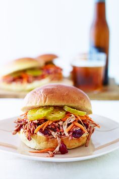 a pulled pork sandwich with pickles and carrots