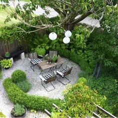 an aerial view of a patio with chairs and table in the middle, surrounded by greenery