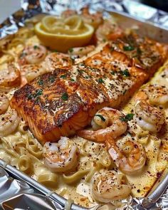 salmon and shrimp on top of pasta in a pan