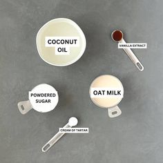 ingredients for coconut oil and oat milk on a gray surface with labels labeled in english