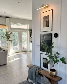 a living room filled with furniture and pictures on the wall next to a door way