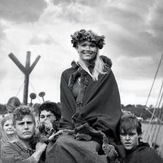 a woman sitting on top of a man's back with other people around her